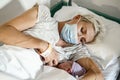 A new mother nursing her newborn boy in mask during pandemic