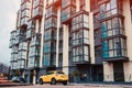 New multi-storey residential building with car parked in front. Modern house Royalty Free Stock Photo