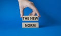 The new norm symbol. Concept words The new norm on wooden blocks. Beautiful blue background. Businessman hand. Business and The