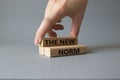 The new norm symbol. Concept words The new norm on wooden blocks. Beautiful grey background. Businessman hand. Business and The