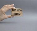 The new norm symbol. Concept words The new norm on wooden blocks. Beautiful grey background. Businessman hand. Business and The