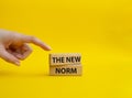 The new norm symbol. Concept words The new norm on wooden blocks. Beautiful yellow background. Businessman hand. Business and The