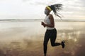 New normal beach running workout of African American woman - young attractive and athletic black girl in face mask training Royalty Free Stock Photo