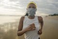 New normal beach running workout of African American woman - young attractive and athletic black girl in face mask training Royalty Free Stock Photo