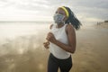 New normal beach running workout of African American woman - young attractive and athletic black girl in face mask training Royalty Free Stock Photo