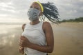 New normal beach running workout of afro American woman - young attractive and athletic black girl in face mask training outdoors Royalty Free Stock Photo