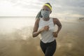 New normal beach running workout of afro American woman - young attractive and athletic black girl in face mask training outdoors Royalty Free Stock Photo