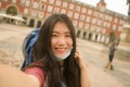 New normal holidays travel in Europe - young happy and beautiful Asian Chinese tourist woman wearing mask taking selfie with Royalty Free Stock Photo