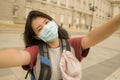 New normal holidays travel in Europe - young happy and beautiful Asian Chinese tourist woman wearing mask taking selfie with Royalty Free Stock Photo