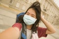 New normal holidays travel in Europe - young happy and beautiful Asian Japanese tourist woman wearing mask taking selfie with Royalty Free Stock Photo