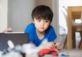 New normal life.Kid with bored face playing plastic blocks, Unhappy Child playing with toys alone in living room. Candid shot