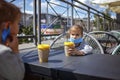 New normal reality, stay safe in street cafe, kids with medical mask waiting for breakfast Royalty Free Stock Photo