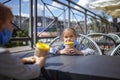 New normal reality, stay safe in street cafe, kids with medical mask waiting for breakfast Royalty Free Stock Photo