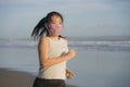 New normal running workout of Asian girl in face mask - young happy and beautiful Korean woman jogging on the beach in post