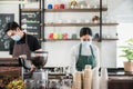 New normal startup small business of coffee shop concept. Male and female barista in face mask and standing behind bar counter in Royalty Free Stock Photo