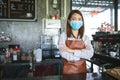 Portrait of Asian woman barista wearing face mask working in coffee shop Royalty Free Stock Photo