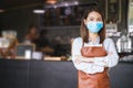 Portrait of Asian woman barista wearing face mask working in coffee shop Royalty Free Stock Photo