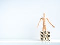 New Normal, words on wooden alphabet cube and wooden figure Royalty Free Stock Photo