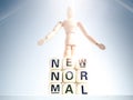 New Normal, words on wooden alphabet cube and wooden figure Royalty Free Stock Photo