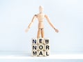 New Normal, words on wooden alphabet cube and wooden figure Royalty Free Stock Photo