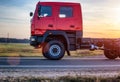 A new off-road truck rides on the road against a sunset. The concept of modern SUVs, departure for travel and expedition, copy
