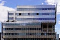 New office building in business center with wall made of steel and glass with blue cloudy sky Royalty Free Stock Photo