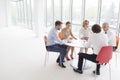 Business colleagues discussing while sitting at table by window in new office Royalty Free Stock Photo