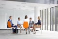 Business colleagues planning strategy while sitting on chairs during meeting Royalty Free Stock Photo