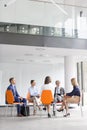 Colleagues planning strategy while sitting on chairs during meeting Royalty Free Stock Photo