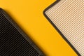 New and old car air filter on the yellow background . Close up.