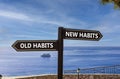 New or old habits symbol. Concept word New habits Old habits on beautiful signpost with two arrows. Beautiful blue sea sky with Royalty Free Stock Photo