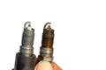 New and old spark plugs on white background