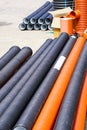 New orange and black plastic pipes on construction site