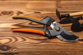 New orange garden pruners on a brown wooden background.