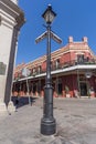 New Orleans, LA/USA - circa February 2016: Pole with street signs and old Colonial House with ironwork galleries