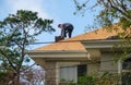 Worker on rooftop demolishing a chimney