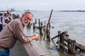 Bearded man above the wreckage of a pier on the Mississippi River