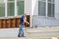 Worker removing siding from old house