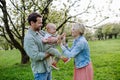 New parents holding small toddler, baby, outdoors in spring nature. Older First-time parents. Royalty Free Stock Photo