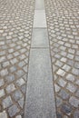 New paving made with grey stone slabs and small stone cube blocks interlocked with sand in curved shape in a pedestrian zone