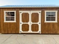 A new potting shed tool building with wood exterior and tin roof on garden driveway Royalty Free Stock Photo