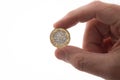 New pound coin held in man`s fingers Royalty Free Stock Photo