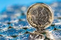 New pound coin introduced in the UK in 2017, front, standing on a layer of coins and on a blue background Royalty Free Stock Photo