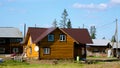 A new private cottage of yellow logs, among the old village houses, is being completed in the summer in Yakutia in the village Royalty Free Stock Photo