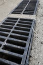 New rainwater grate on the road or sidewalk, installation in concrete. City sewage system for draining water during heavy rain Royalty Free Stock Photo