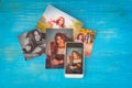 New reality and tradition. Color photographs of a young girl and a cell phone with her image on a blue wooden background Royalty Free Stock Photo