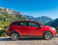 A new red car pulled over on the side of a remote mountain road Royalty Free Stock Photo