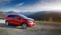 A new red car pulled over on the side of a remote mountain road Royalty Free Stock Photo