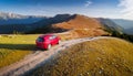 A new red car pulled over on the side of a remote mountain road Royalty Free Stock Photo