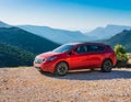 A new red car pulled over on the side of a remote mountain road Royalty Free Stock Photo